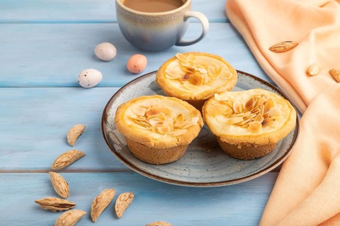 Traditional portuguese cakes pasteis de nata, custard small pies with almonds with cup of coffee on