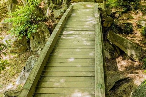 Shaded wooden footbridge in Japanese Shukkeien Gardens in Hiroshima, Japan, Asia