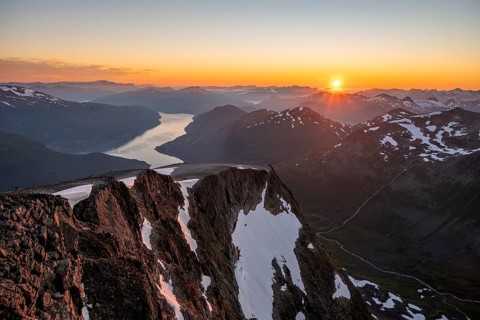 View of mountains and fjord Faleidfjorden, sun star at sunset, summit of Skala, Loen, Norway,