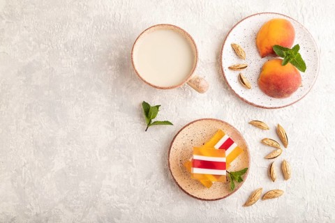 Almond milk and peach jelly on gray concrete background. top view, flat lay, copy space