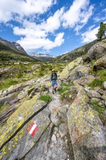 Mountaineers on a hiking trail in front of a picturesque mountain landscape, rocky mountain peaks