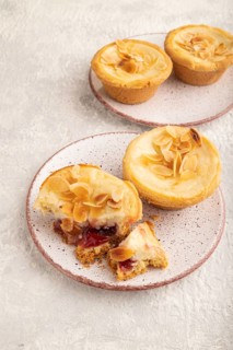 Traditional portuguese cakes pasteis de nata, custard small pies with almonds on gray concrete