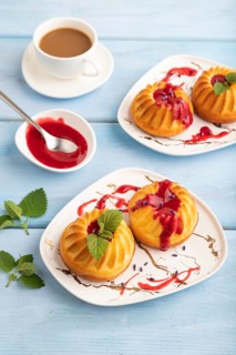 Semolina cheesecake with strawberry jam, lavender, cup of coffee on blue wooden background. side