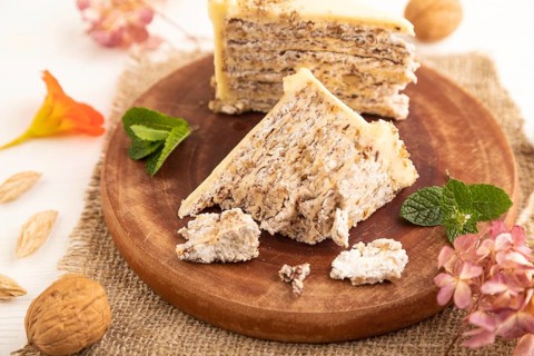 Walnut and almond cake on white wooden background and linen textile. side view, close up, selective