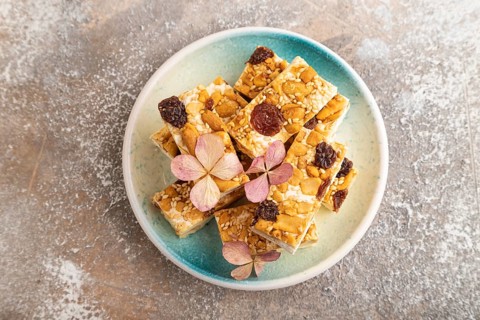 Traditional candy nougat with nuts and sesame on brown concrete background. top view, flat lay,