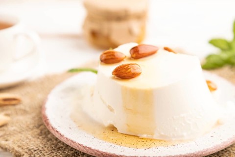 Ricotta cheese with honey and almonds on white wooden background and linen textile. side view,