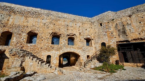 Inner courtyard of an old fortress with stone walls and arched windows, Chlemoutsi, High Medieval