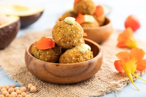 Falafel with guacamole on blue wooden background and linen textile. Side view, close up, selective