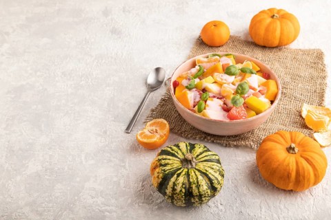 Vegetarian fruit salad of yogurt pumpkin, tangerine, pomegranate, grapefruit, basil microgreen
