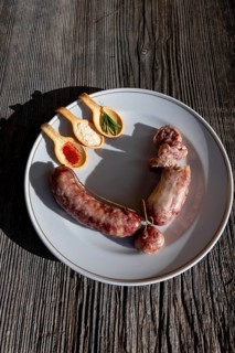 A Plate with Luganighe Sausage and with Species in Spoon Like Saffron and Parmesan Cheese and