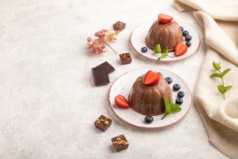 Chocolate jelly with strawberry and blueberry on gray concrete background and linen textile. side
