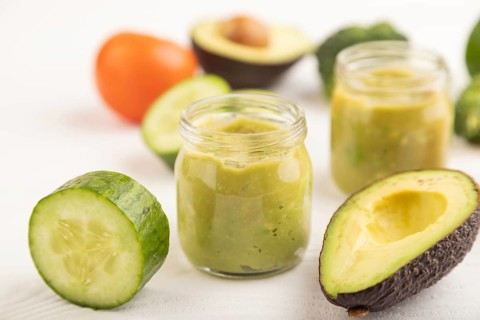 Baby puree with vegetable mix, broccoli, tomatoes, cucumber, avocado infant formula in glass jar on