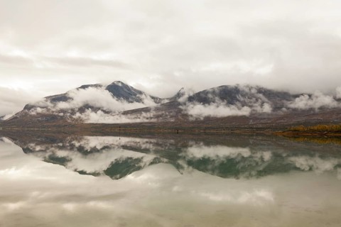 Beautiful foggy mood with lake reflection in the fjord in northern Norway Kjerringstraumen Bru