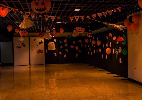 Dimly lit room decorated with hand made Halloween decorations of ghost, jack-o-lanterns and