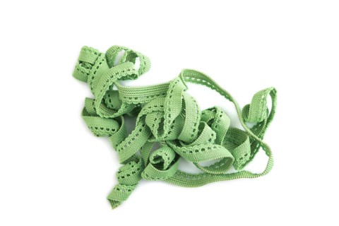 Green braid isolated on white background. Top view, flat lay, close up