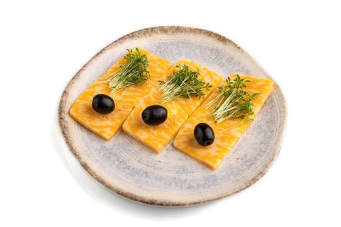 Marble cheese with olives and watercress microgreen isolated on white background. side view, close