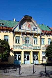 Art Nouveau building on a sunny day with blue sky and green roof, artistic facade, House of