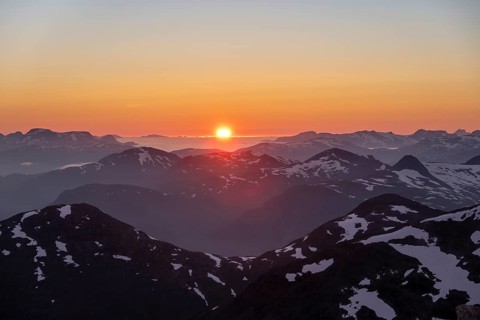 Sunset behind the mountains, mountain panorama with remnants of snow from the summit of Skala,