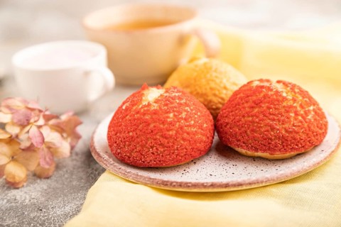 Traditional french custard dessert shu cake and cup of green tea on brown concrete background and