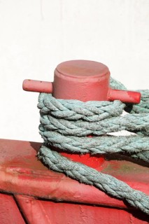 Red ship's bollard wrapped with ship's rope, mooring line, Germany, Europe