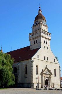 A sunny day illuminates a church with an onion dome and shade on the forecourt, Roman Catholic