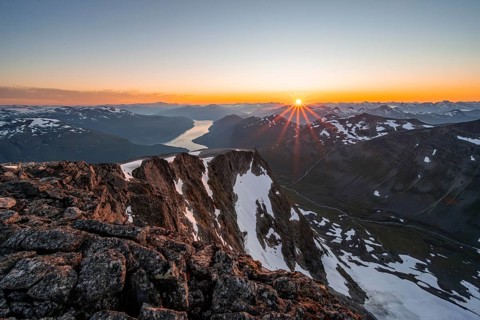 View of mountains and fjord Faleidfjorden, sun star at sunset, summit of Skala, Loen, Norway,
