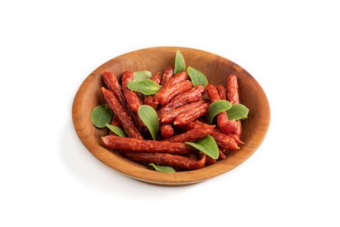 Small smoked sausage with borage microgreen isolated on white background. Side view, close up