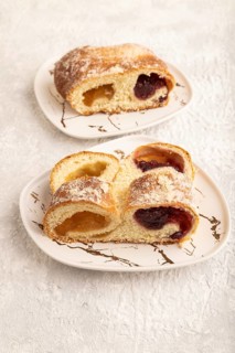 Homemade sweet bun with apricot jam on gray concrete background. side view, close up