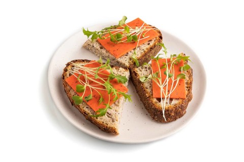 Grain bread sandwiches with red tomato cheese and mizuna cabbage microgreen isolated on white