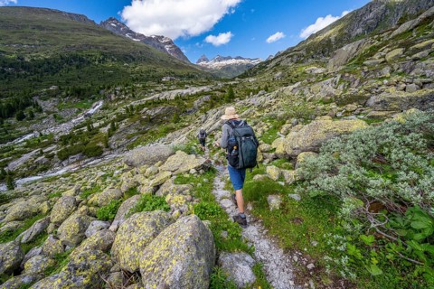 Mountaineers on a hiking trail in front of a picturesque mountain landscape, rocky mountain peaks