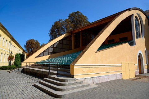 A modern yellow open-air grandstand with many steps on a sunny day, church, officers' palace,