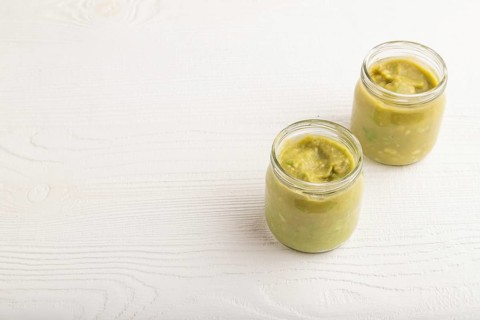Baby puree with vegetable mix, broccoli, tomatoes, cucumber, avocado infant formula in glass jar on