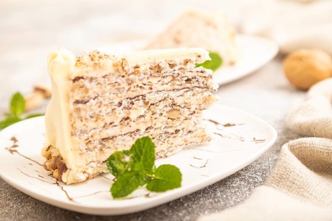 Walnut and almond cake on brown concrete background and linen textile. side view, close up,