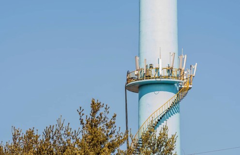 Closeup of spiral staircase leading to cellphone transmission array on tall concrete column with