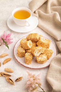 Traditional turkish delight (rahat lokum) with cup of green tea on a gray concrete background and