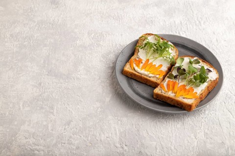 White bread sandwiches with cream cheese, calendula petals and microgreen radish and tagetes on