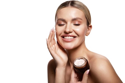 Beauty portrait of model with natural make-up holding a jar of cream. Fashion shiny highlighter on