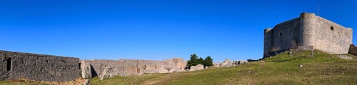 Panoramic picture, Panoramic view of a historic fortress with long walls under a vast blue sky,
