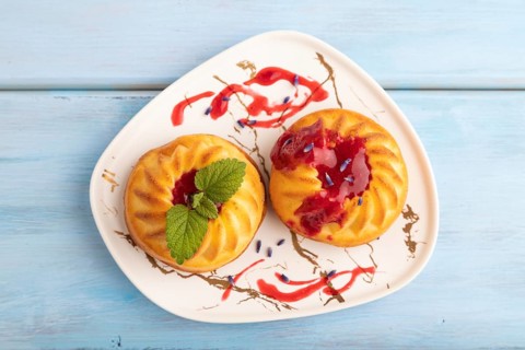 Semolina cheesecake with strawberry jam, lavender, on blue wooden background. top view, flat lay,