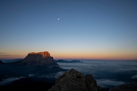 Sunrise over a sea of fog with the peaks of the Sella massif in the background, Corvara, Dolomites,