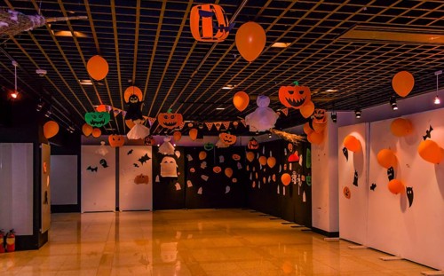 Dimly lit room decorated with hand made Halloween decorations of ghost, jack-o-lanterns and