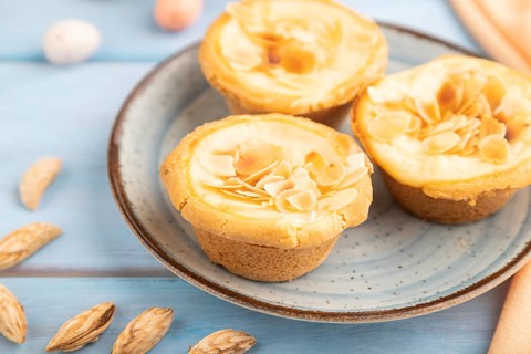 Traditional portuguese cakes pasteis de nata, custard small pies with almonds with cup of coffee on