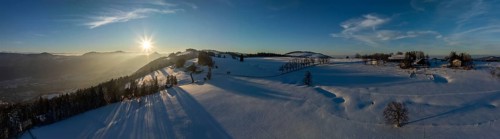 Sun shining through bare trees, snowy winter landscape on the Brunnersberg, Solothurn, Switzerland,