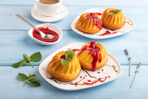 Semolina cheesecake with strawberry jam, lavender, cup of coffee on blue wooden background. side