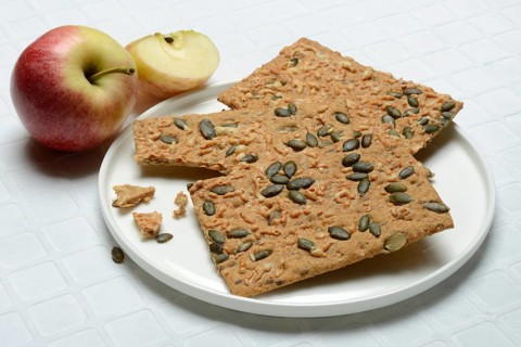 Crispbread with seeds on a plate and apple