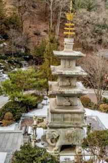 Four story stone carved pagoda on plinth of three elephants at Buddhist temple in South Korea