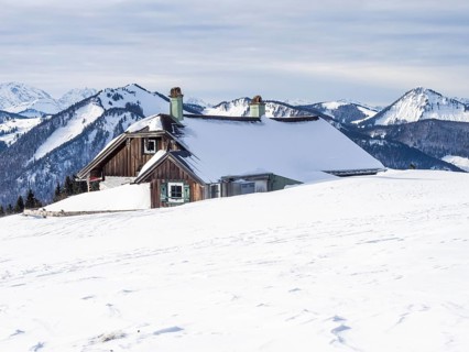 Winter atmosphere, snow-covered landscape, snow-covered alpine peaks, alpine hut on the
