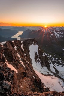 View of mountains and fjord Faleidfjorden, sun star at sunset, summit of Skala, Loen, Norway,