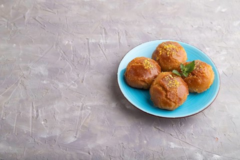 Homemade traditional turkish dessert sekerpare with almonds and honey on gray concrete background.