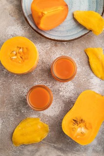 Baby puree with fruits mix, pumpkin, persimmon, mango infant formula in glass jar on brown concrete